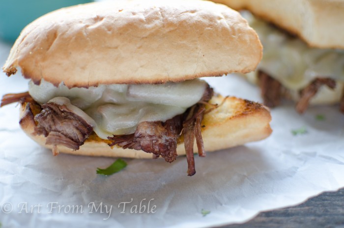 Roast beef sandwich with provolone cheese melting over the beef. 
