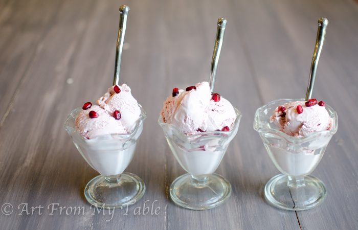 Three dessert dishes filled with pomegranate ice cream. 