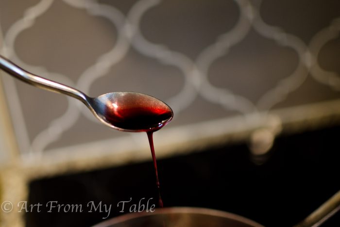 Pomegranate reduction on a spoon.