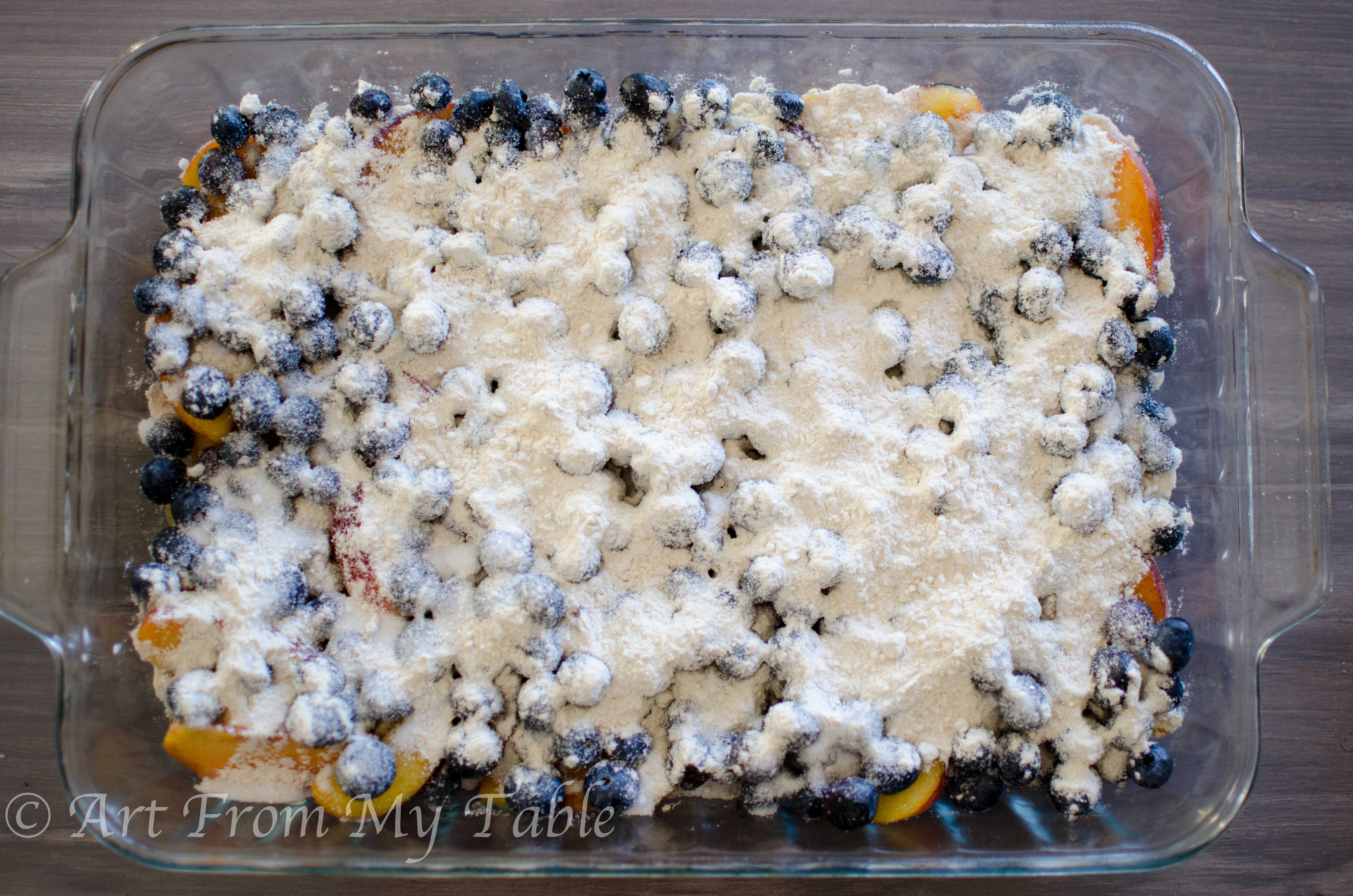 Fresh peaches and blueberries with sugar and flour sprinkled over top.