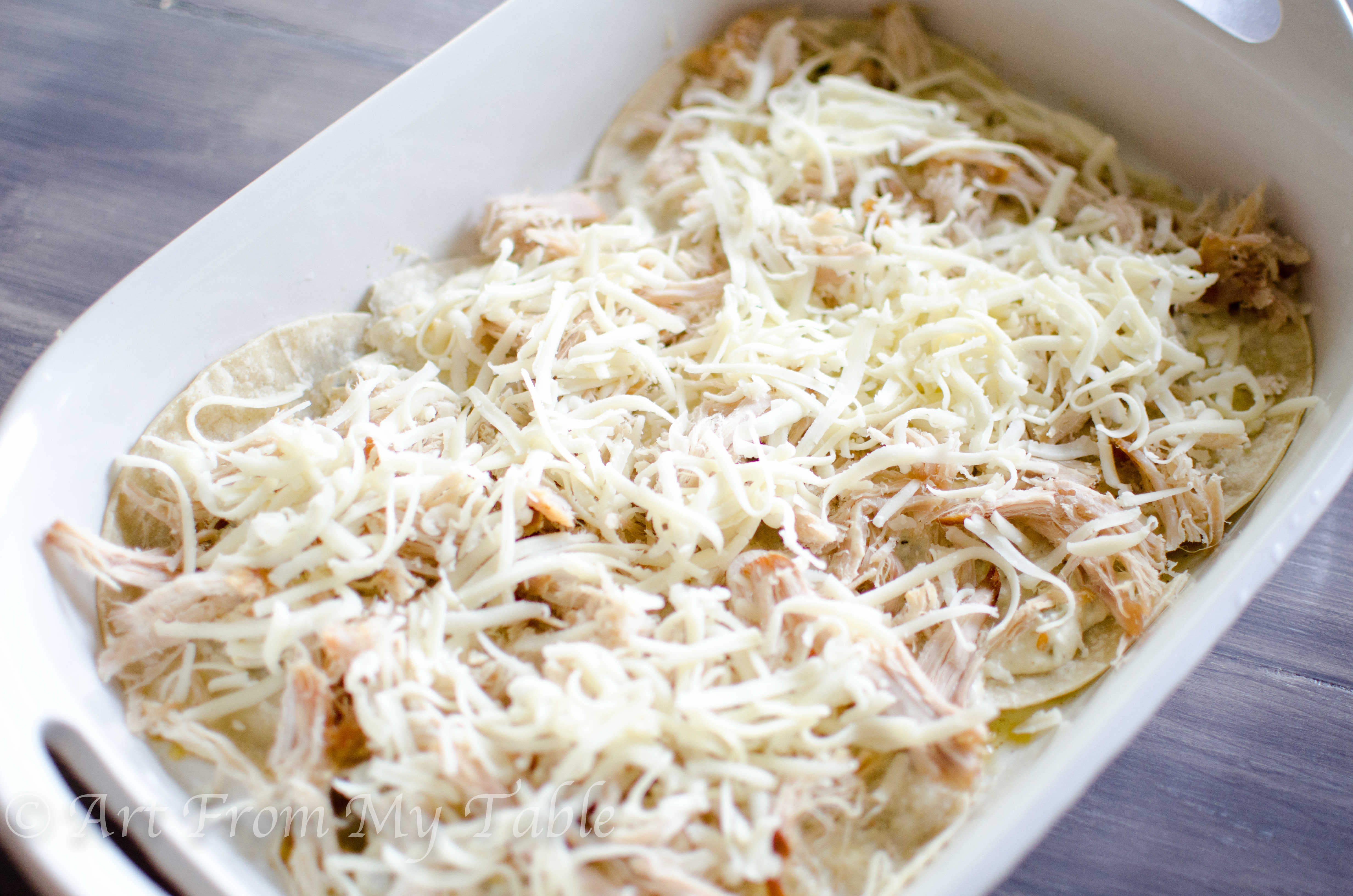 Layer of cheese added to the carnitas casserole verde.
