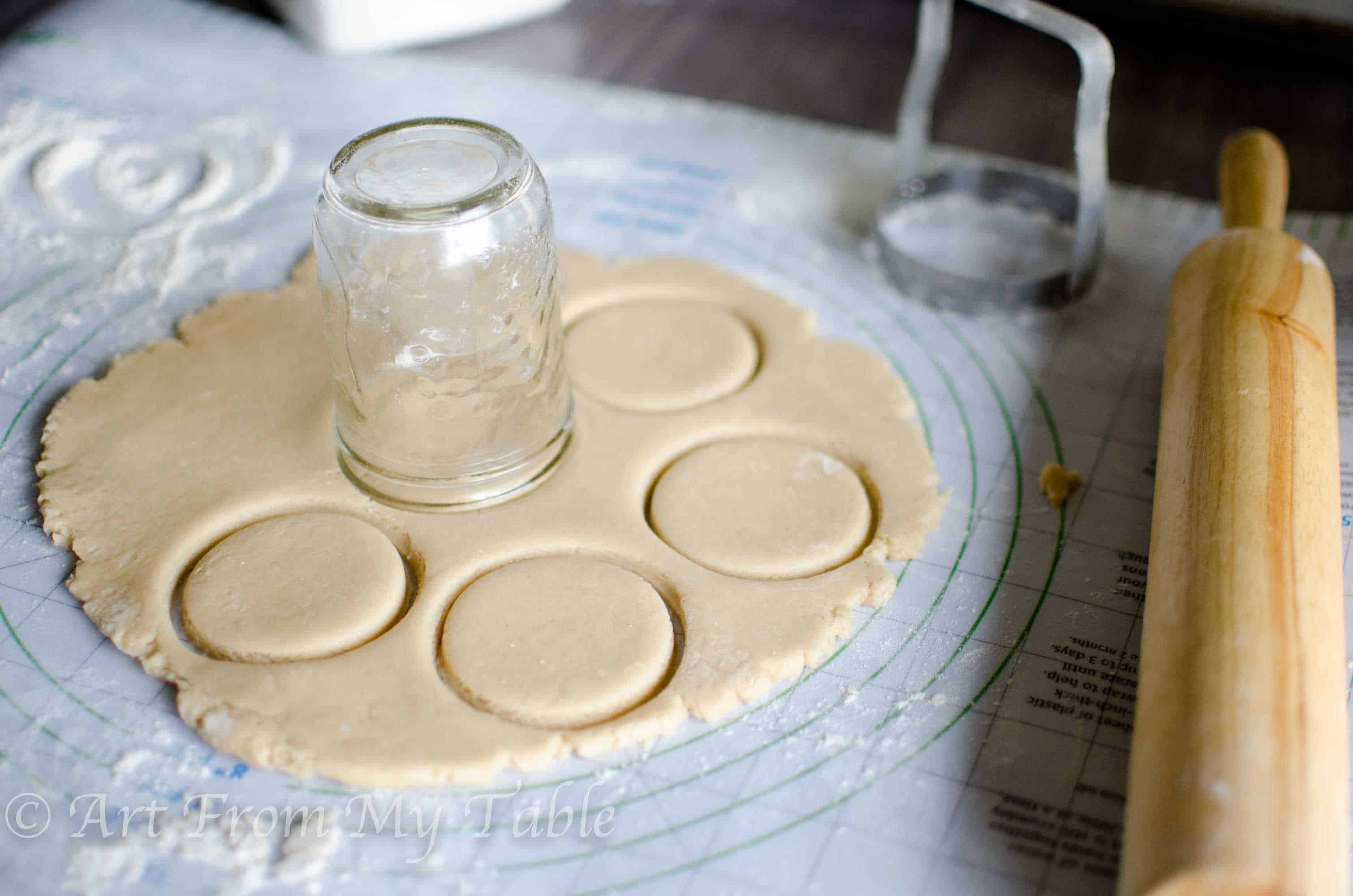 Sugar cookie dough rolled into a disc using a mason jar upside down to cut circles. 