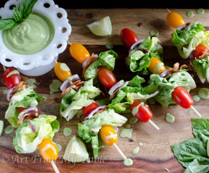 BLT Salad skewers on a cutting board with Avocado dressing for dipping.