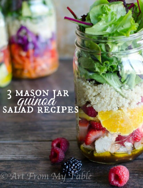 Mason jar salad with lettuce, quinoa and fresh fruit, two other types of jar salads in the background.