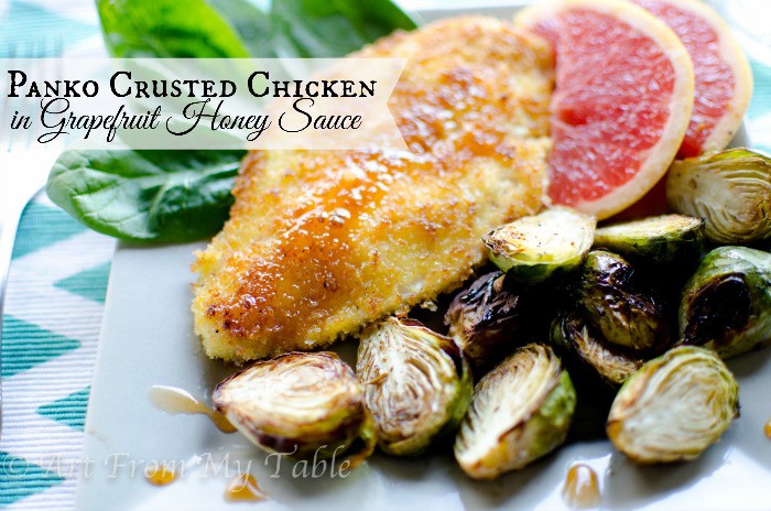 Panko breaded chicken breast with grapefruit honey sauce served with slices of grapefruit and roasted brussels sprouts.
