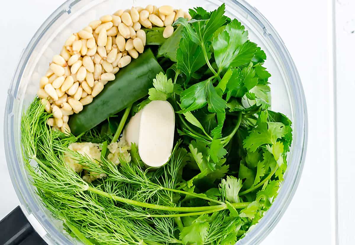 cilantro, dill, garlic, jalapeno and pine nuts in a food processor before being blended.
