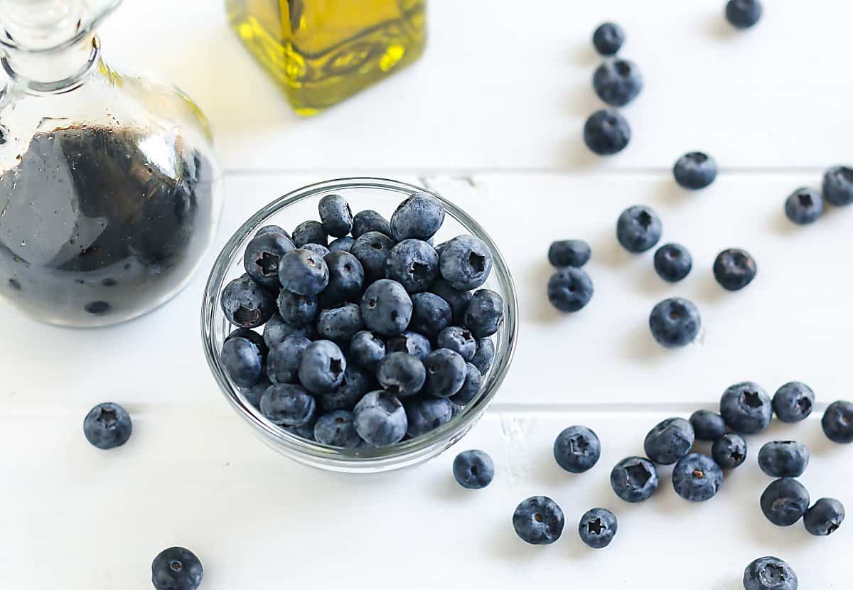 ingredients for homemade blueberry balsamic vinaigrette: blueberries, olive oil, balsamic vinegar