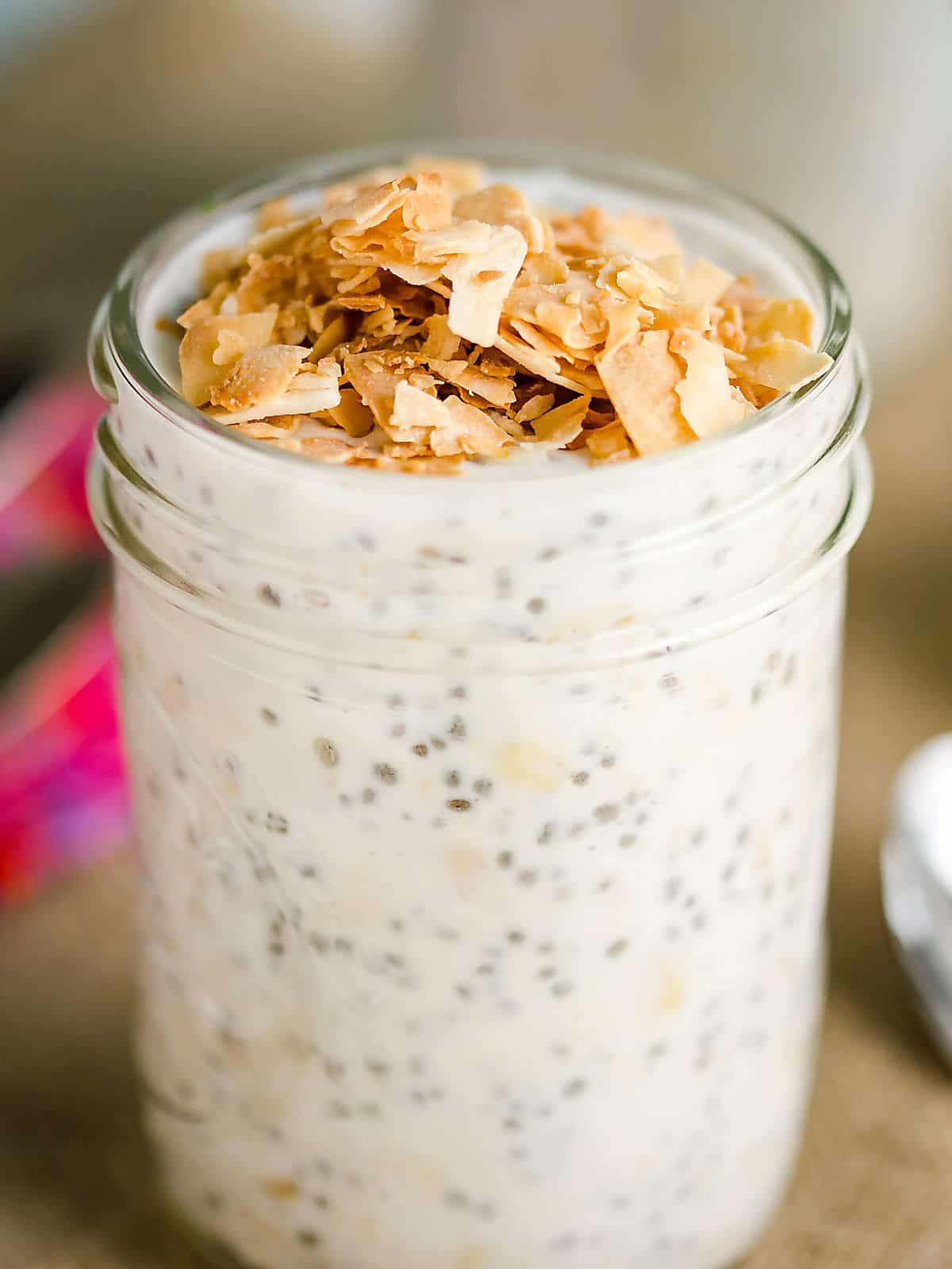 coconut overnight oats in a mason jam jar topped with golden toasted oats.