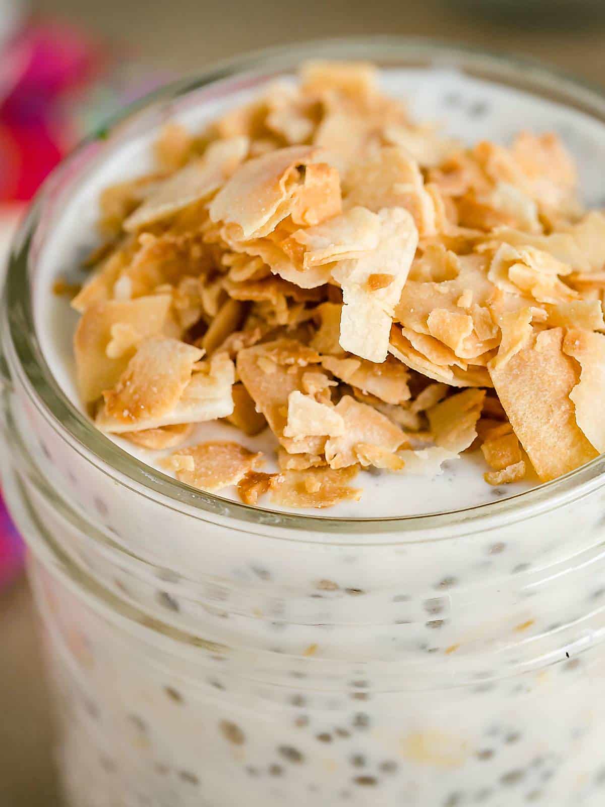 close up image of overnight oats topped with toasted coconut chips.