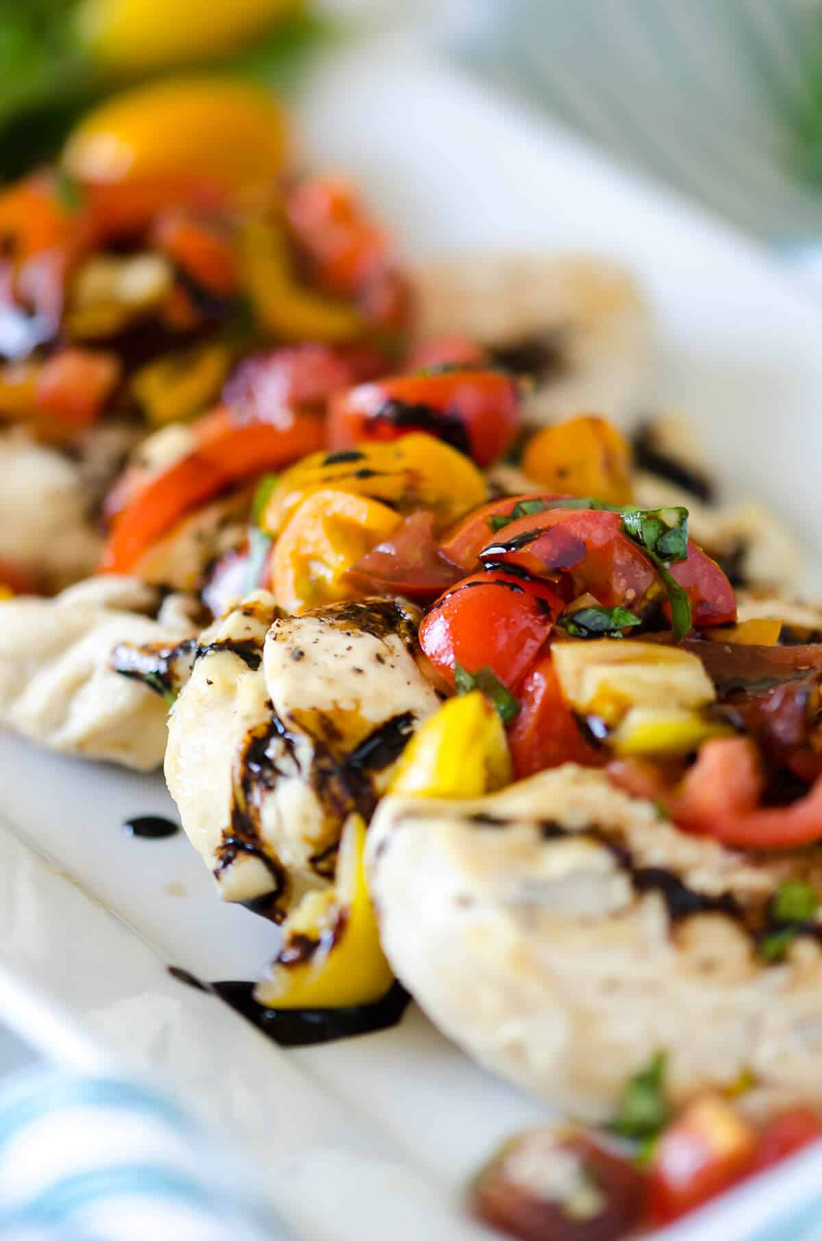Chicken breasts topped with red, orange and yellow tomatoes and fresh basil marinated in olive oil and balsamic vinegar