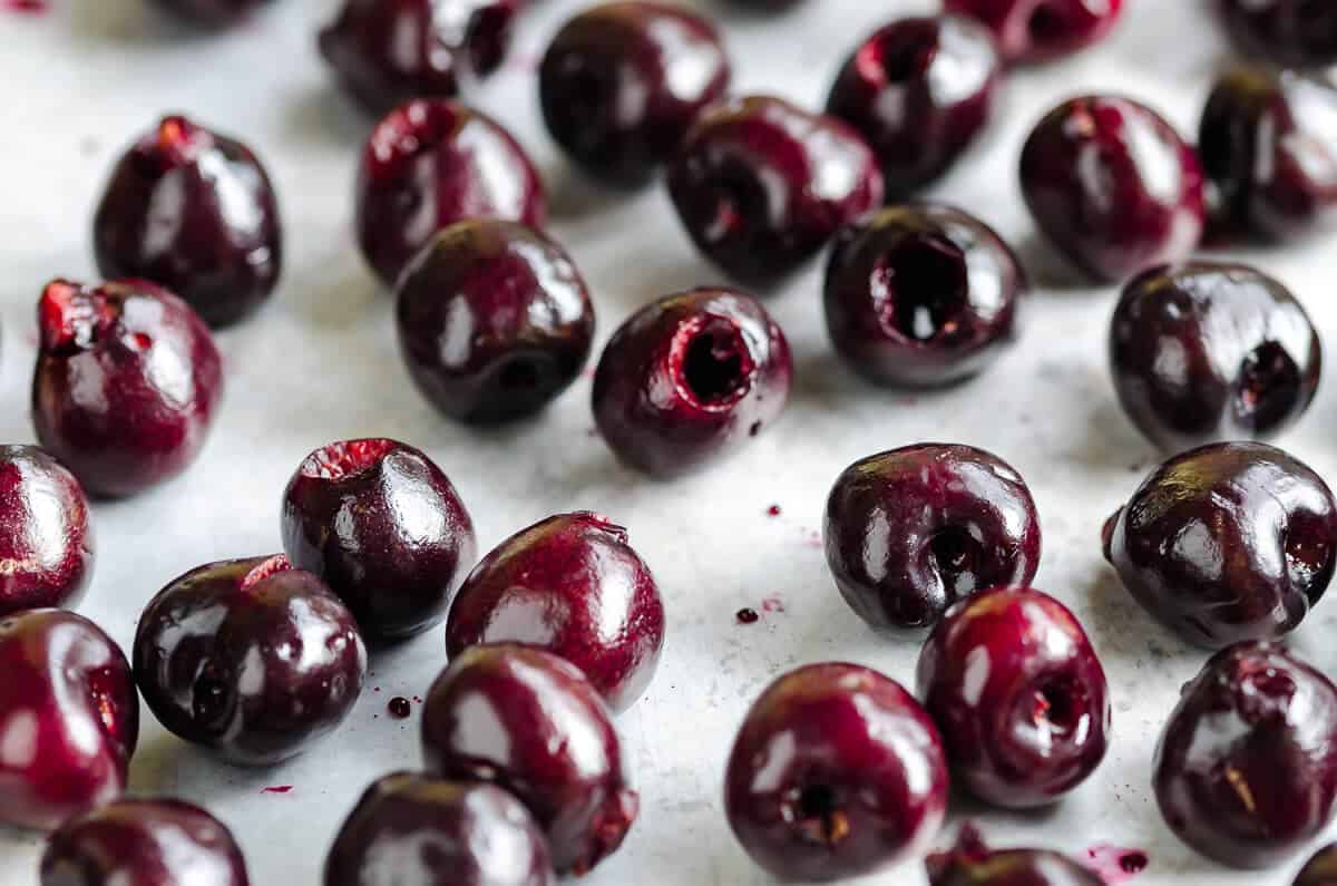 vibrant deep red fresh pitted cherries spread out on a sheet pan