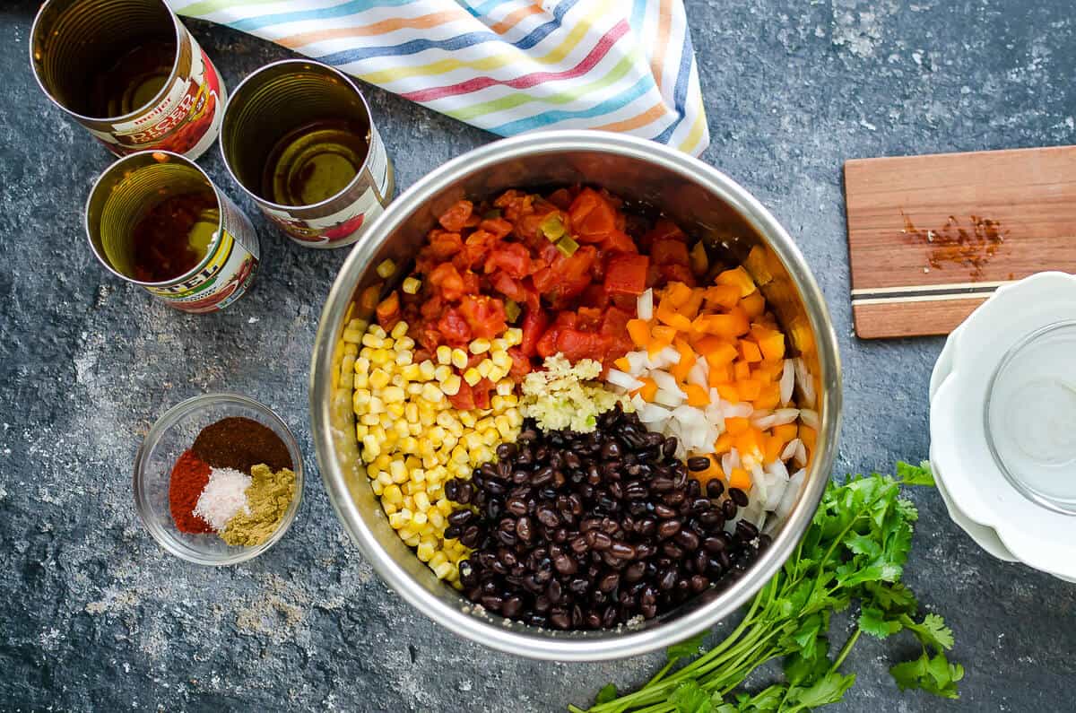 insert of instant pot filled with corn, black beans, onions, peppers and diced tomatoes