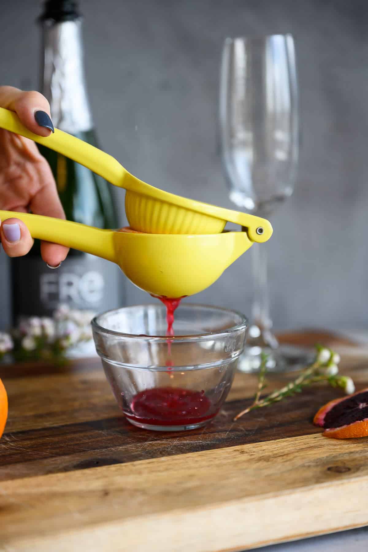 juice from blood oranges being squeezed through citrus juicer