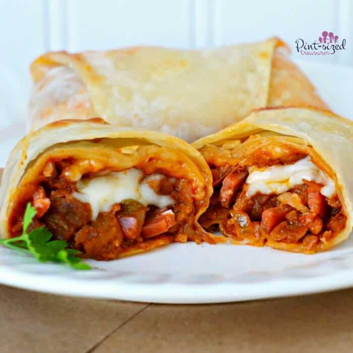 homemade pizza eggroll split in half to show the pepperoni and cheese on the inside.
