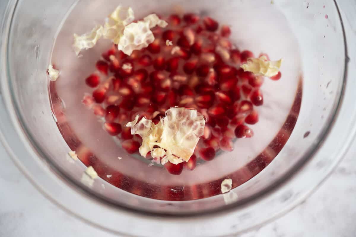 pomegranate arils in a bowl of water