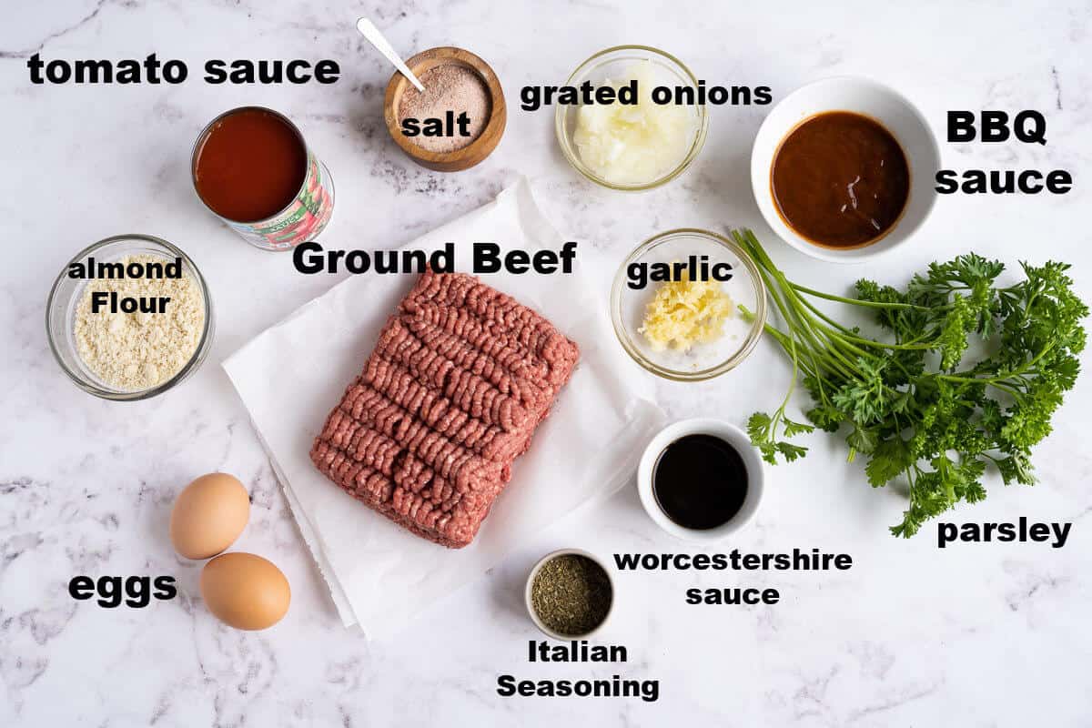 ingredients for low carb meatloaf: ground beef, tomato sauce, onions, almond flour, garlic, Italian seasoning, worcestershire sauce, bbq sauce, eggs, and parsley