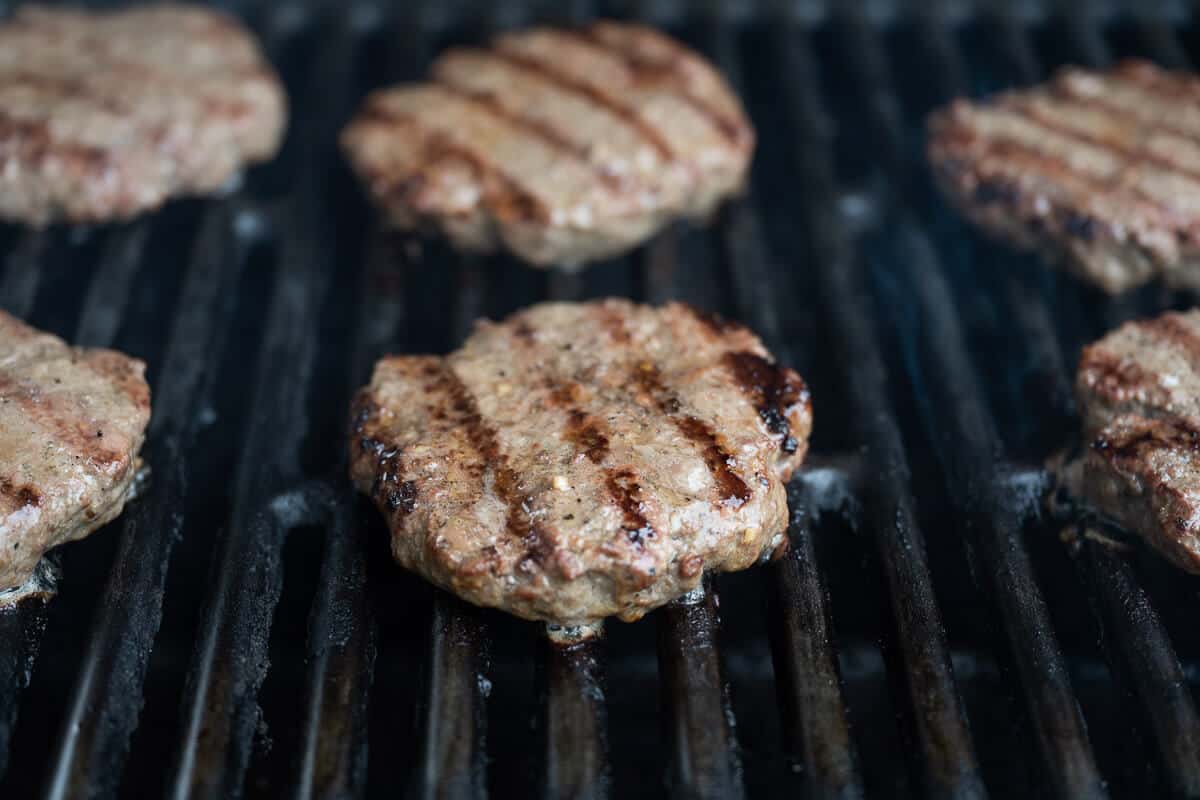 6 juicy burgers on the grill, showing grill marks