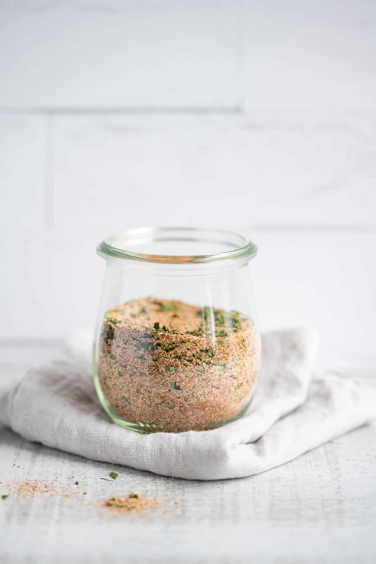 Homemade Seasoned Salt in a glass Weck jar, sitting on top of a gray folded towel.