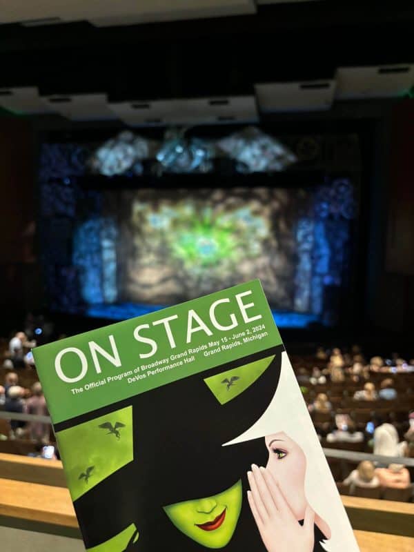 Program cover of Broadway's production "Wicked" with the stage blurred in the background