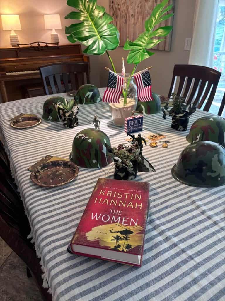 camouflage table scape with "The Women" book.