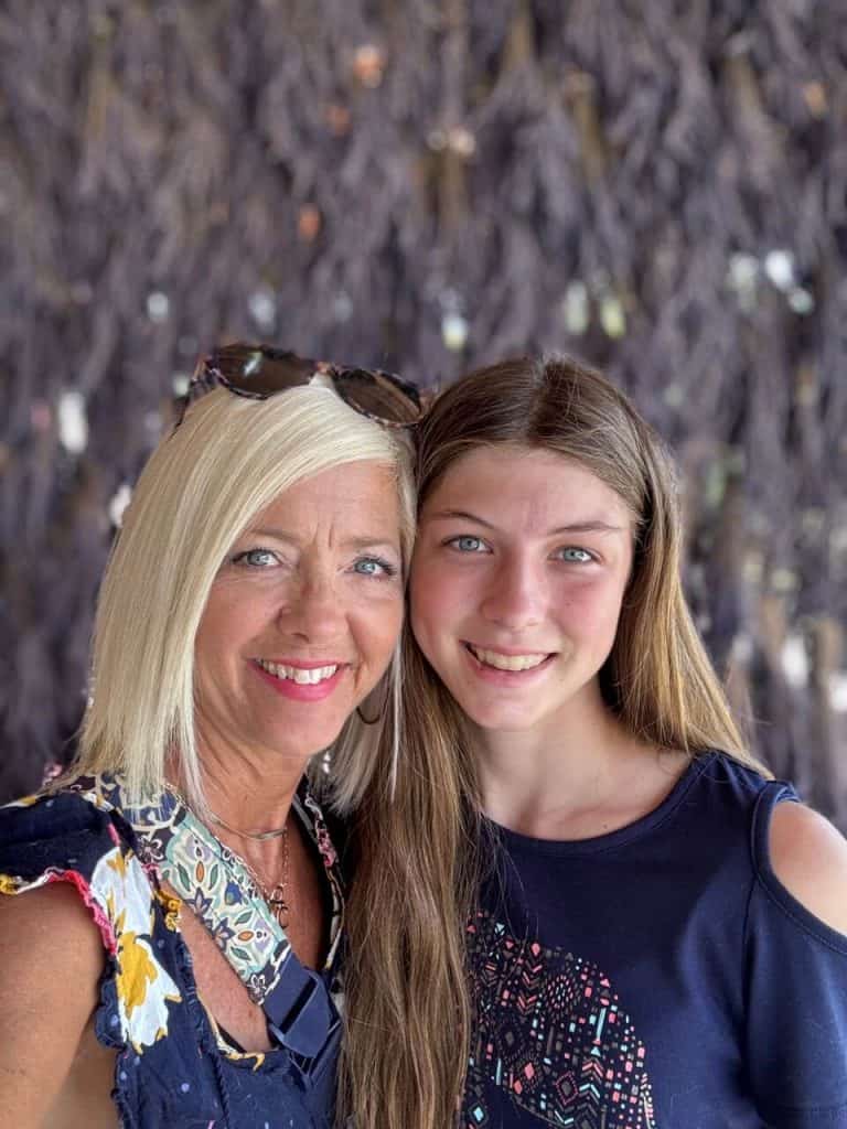 Mom and daughter standing in front of a wall of dried lavender bunches.