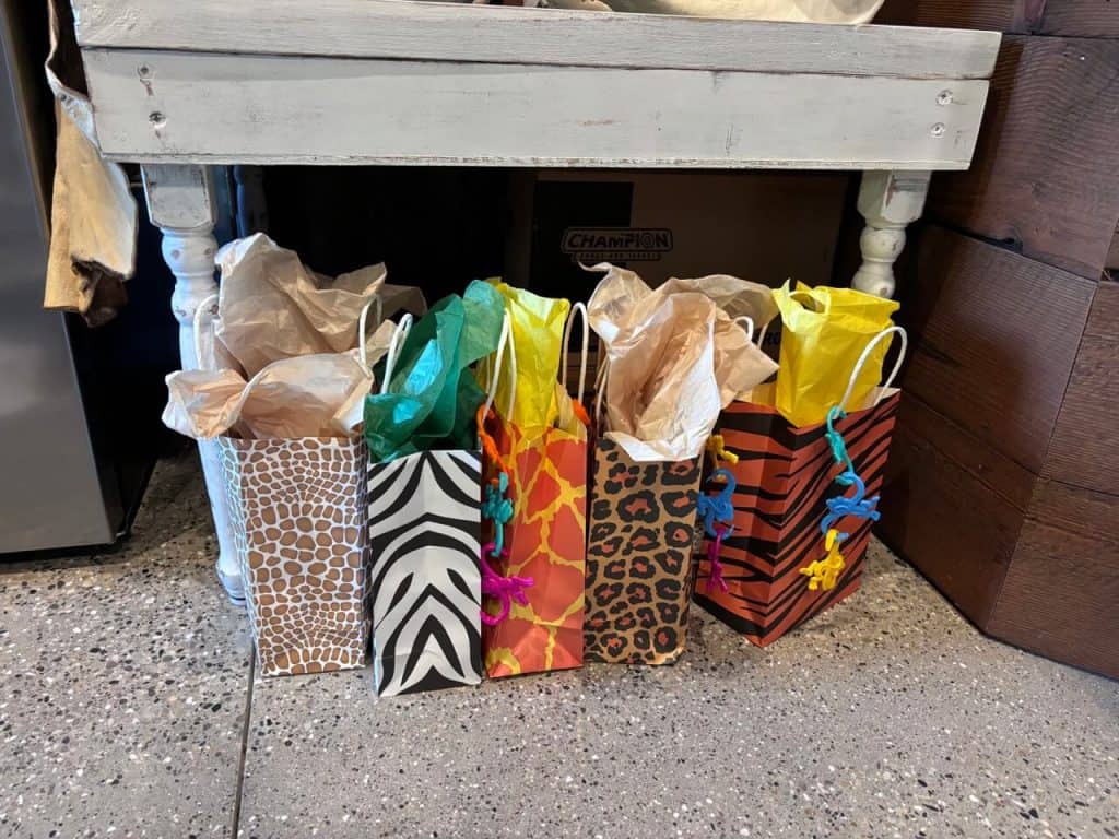 Swag bags for The Lioness book club. 5 bags lined up in a row, all animal prints.