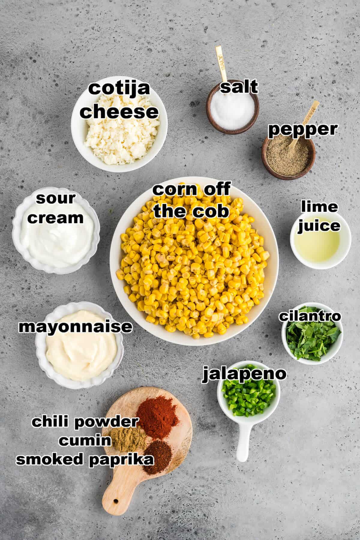 Ingredients for Elote (Mexican street corn) dip. Corn off the cob, sour cream mayo, chili powder, cumin, smoked paprika, jalapeno, cilantro, lime juice, salt, pepper, and cotija cheese.