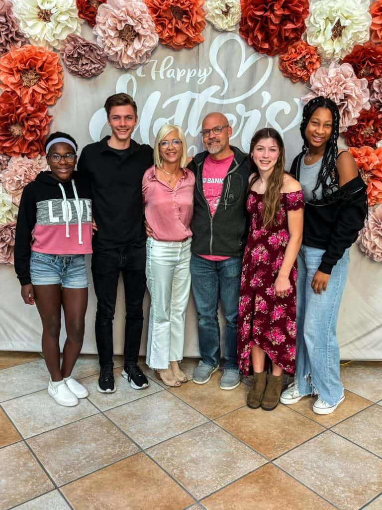 Family photo on Mother's day taken at church in front of a Mother's Day backdrop