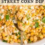 A spoon full of Mexican Street Corn Dip hovering over the serving dish of dip. Text overlay reads: Mexican Street corn Dip.